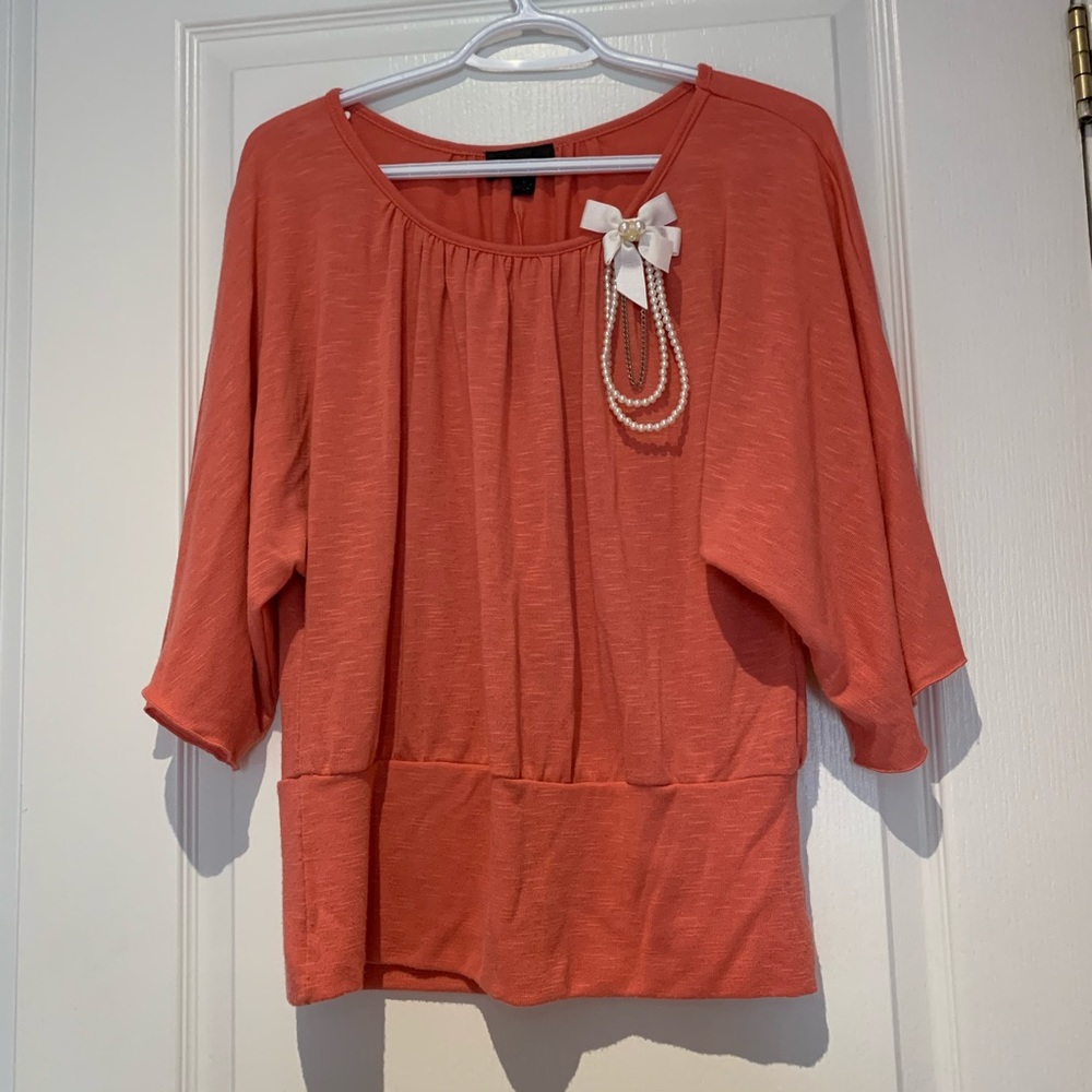 Coral batwing top with brooch detail